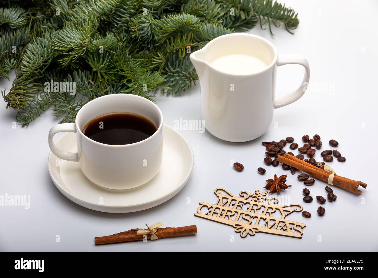 Weihnachtsdekor. Tasse Espresso-Kaffee mit Milch, Weihnachtsbäumen und Holztexten Frohe Weihnachten. Ansicht von oben. Selektiver Fokus Stockfoto