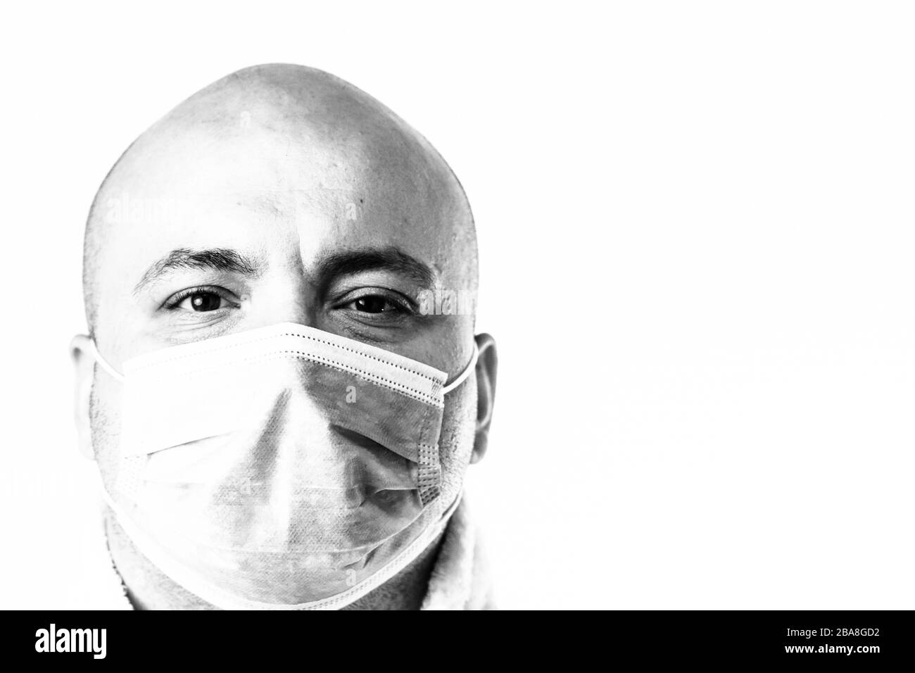 Detail BW Foto des kranken jungen Mannes mit medizinischer Gesichtsmaske zeigt die auf Weiß isolierte Covid 19-Krankheit. Covid-19-Ausbruch, Grippeverunreinigung Stockfoto