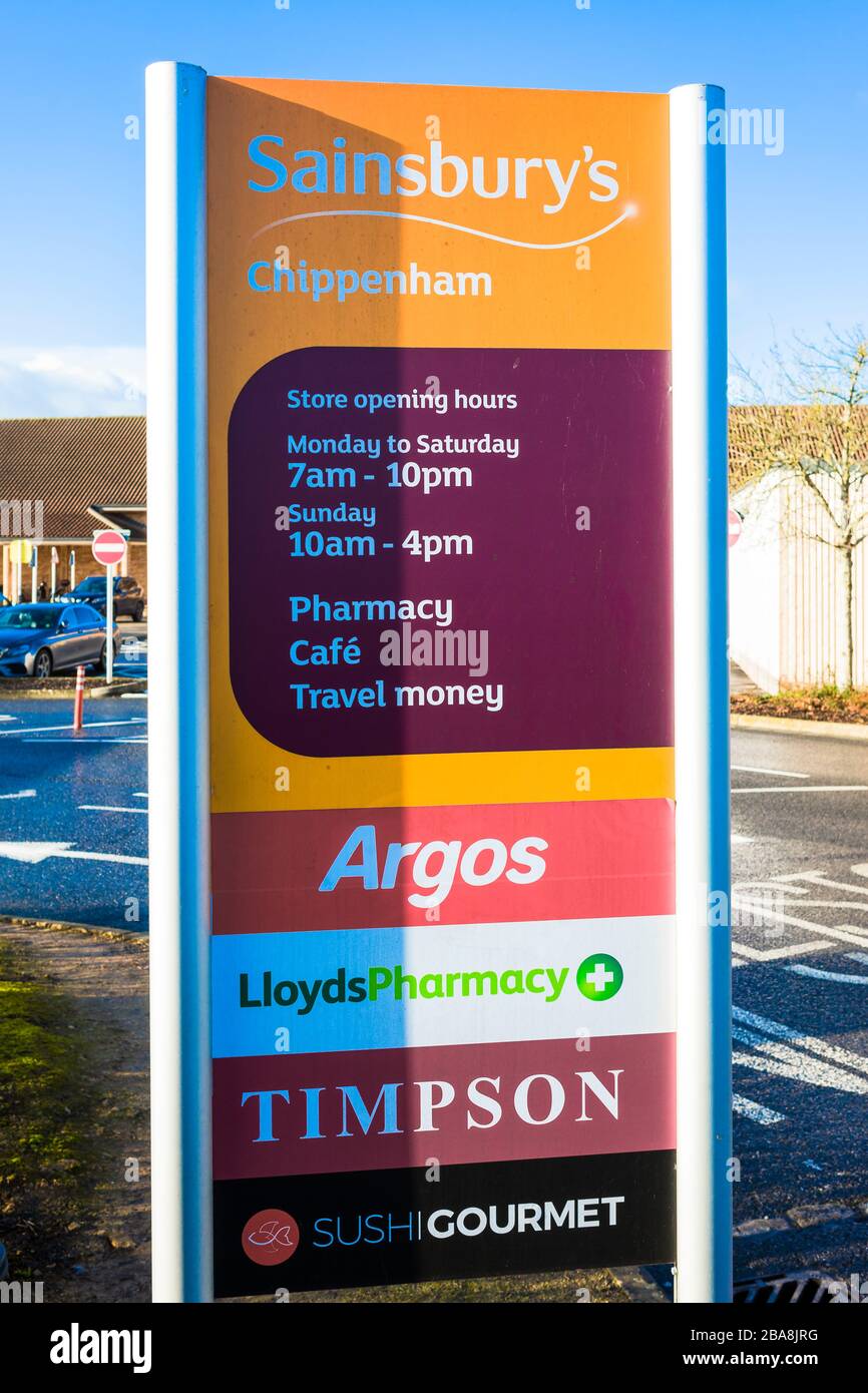 Hinweistafel außerhalb der Chippenham Filiale von Sainsbury's mit den Öffnungszeiten und einer Liste von Franchises, die im Geschäft erhältlich sind Stockfoto