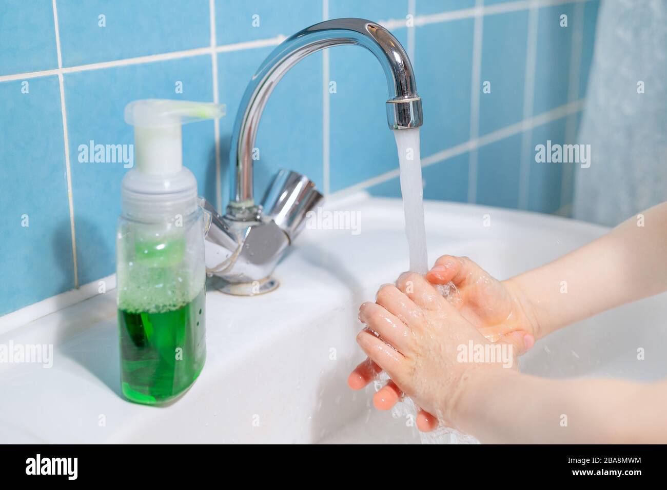 Das Kind wäscht seine Hände mit flüssiger antibakterieller Seife Stockfoto
