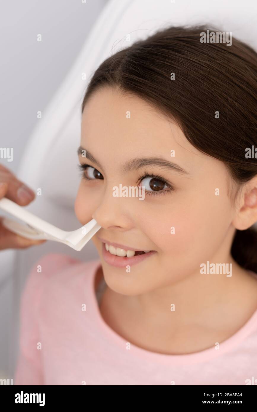 Teilansicht des entnenden Arztes, der die Nase eines lächelnden Kindes mit  Nasenspekulum untersucht Stockfotografie - Alamy