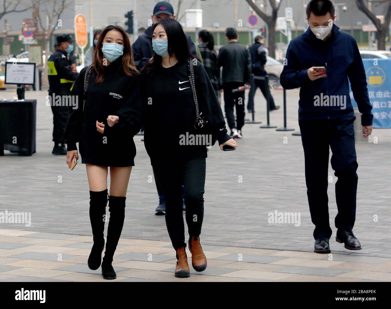 Peking, China. März 2020. Chinesen tragen immer noch schützende Gesichtsmasken, während sie in der Innenstadt spazieren, da die Bedrohung durch das tödliche Coronavirus (Covid-19) am Donnerstag, 26. März 2020 in Peking verblasst. Chinas Hauptstadt kehrt langsam in den Normalzustand zurück, während die Zahl der neuen Coronavirus-Fälle und die Rückkehr des Frühlingswetters stark gefallen sind. Foto von Stephen Shaver/UPI Credit: UPI/Alamy Live News Stockfoto