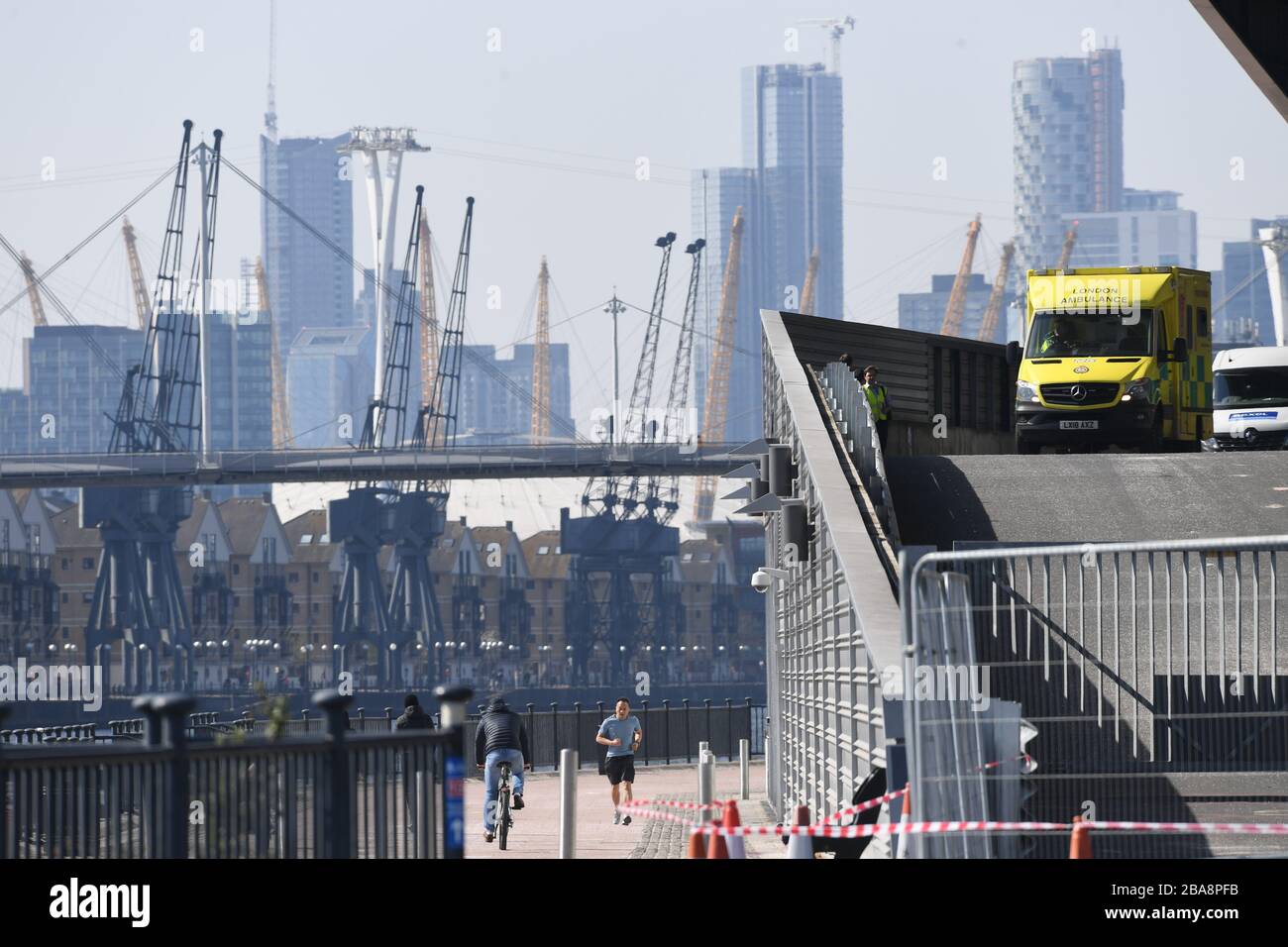 Ein Dienstfahrzeug von London Ambulance wartet auf einer Rampe im Excel Center im Osten Londons, das zu einem temporären Krankenhaus - dem NHS Nightingale Hospital - mit zwei Stationen, jeweils 2.000 Betten, gemacht wird, um die Coronavirus Pandemie zu bekämpfen. Stockfoto