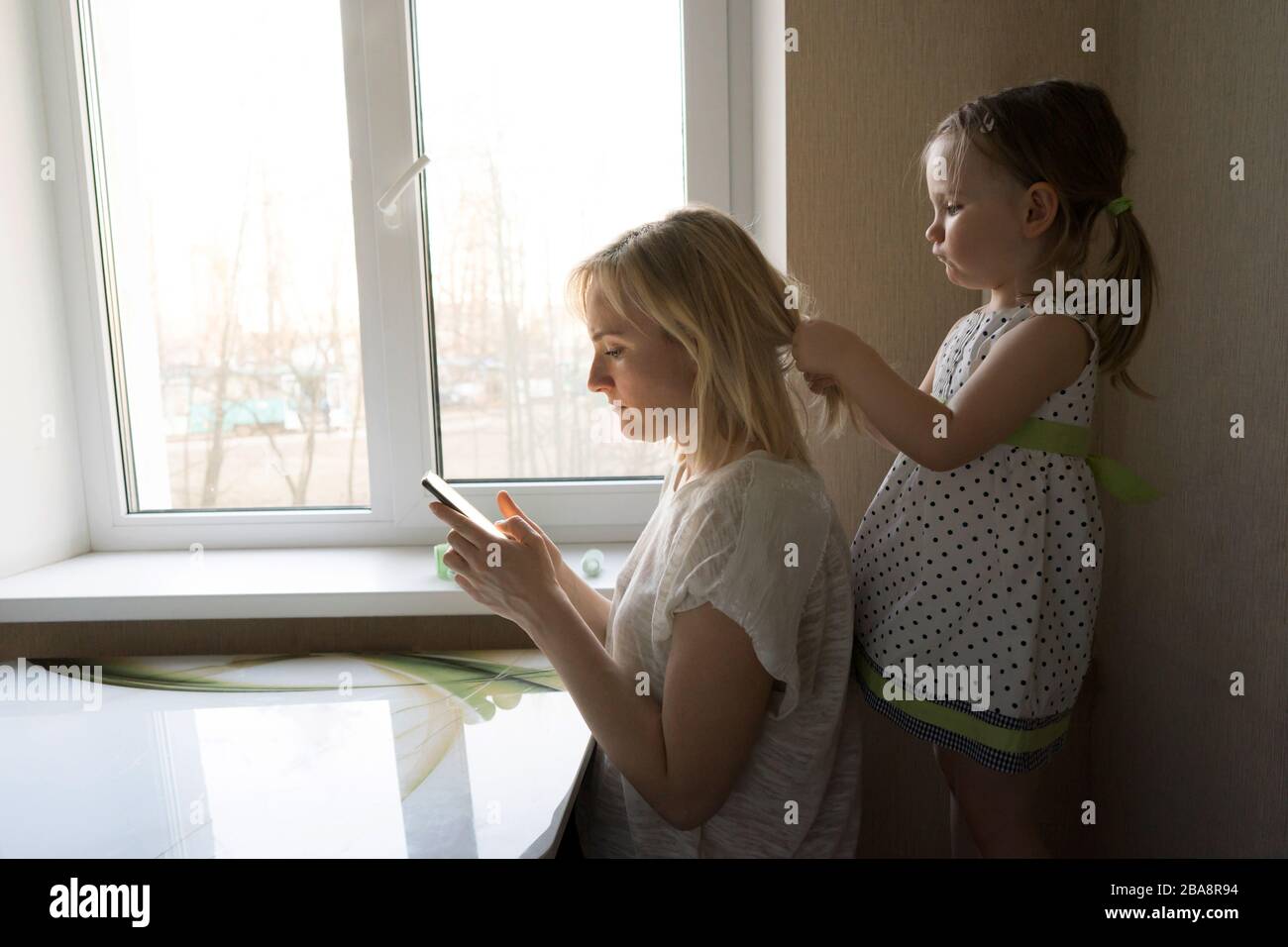 Mutter und Tochter sitzen am Fenster. Stockfoto