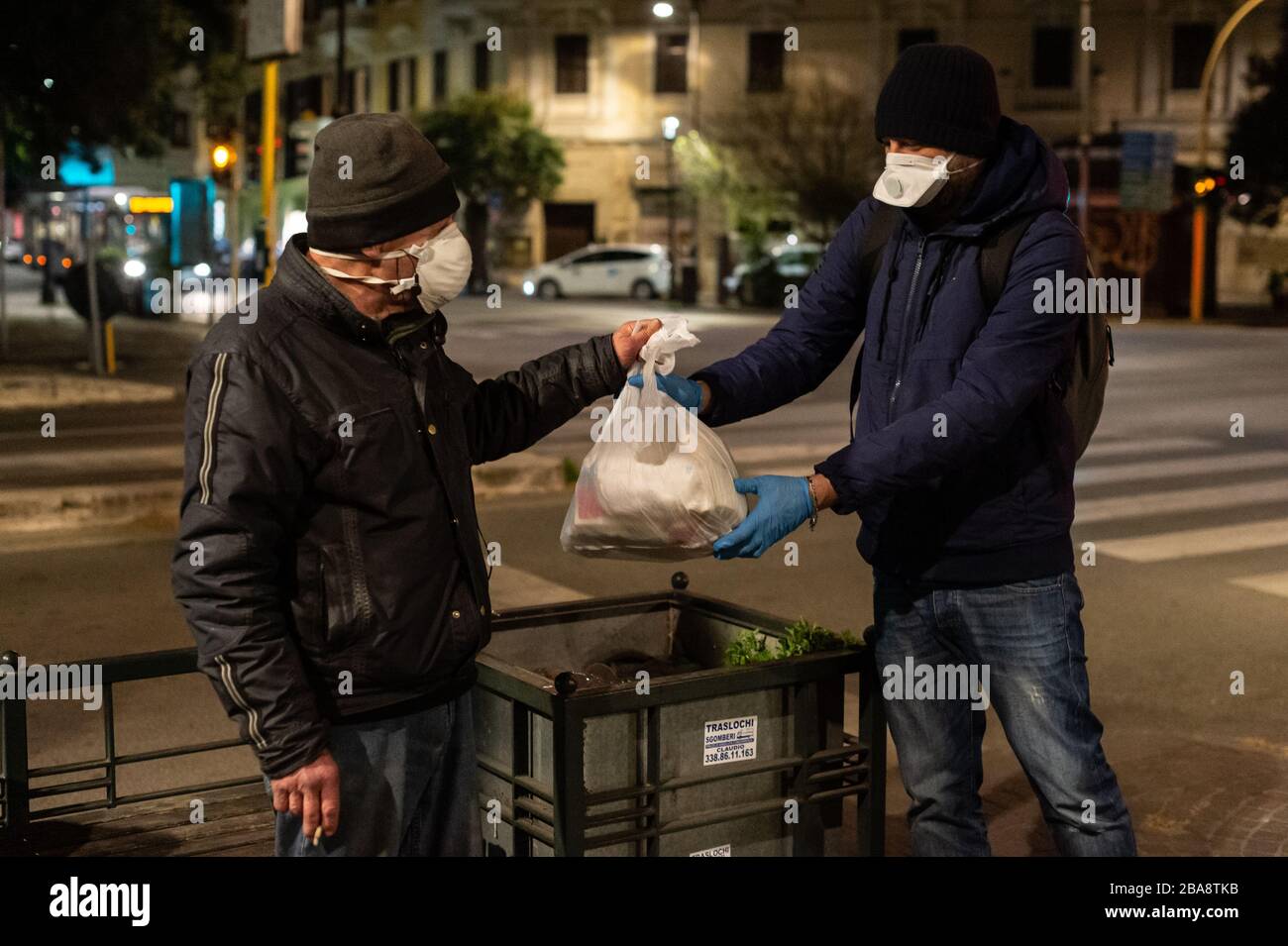 In Rom verteilen die Freiwilligen der Gemeinschaft von Sant'Egidio während der schrecklichen Coronavirus Epidemie, die Italien heimgesucht hat, Mahlzeiten und Gesundheitsdienste an Obdachlose und andere benachteiligte Menschen, die auf den Straßen leben. Stockfoto