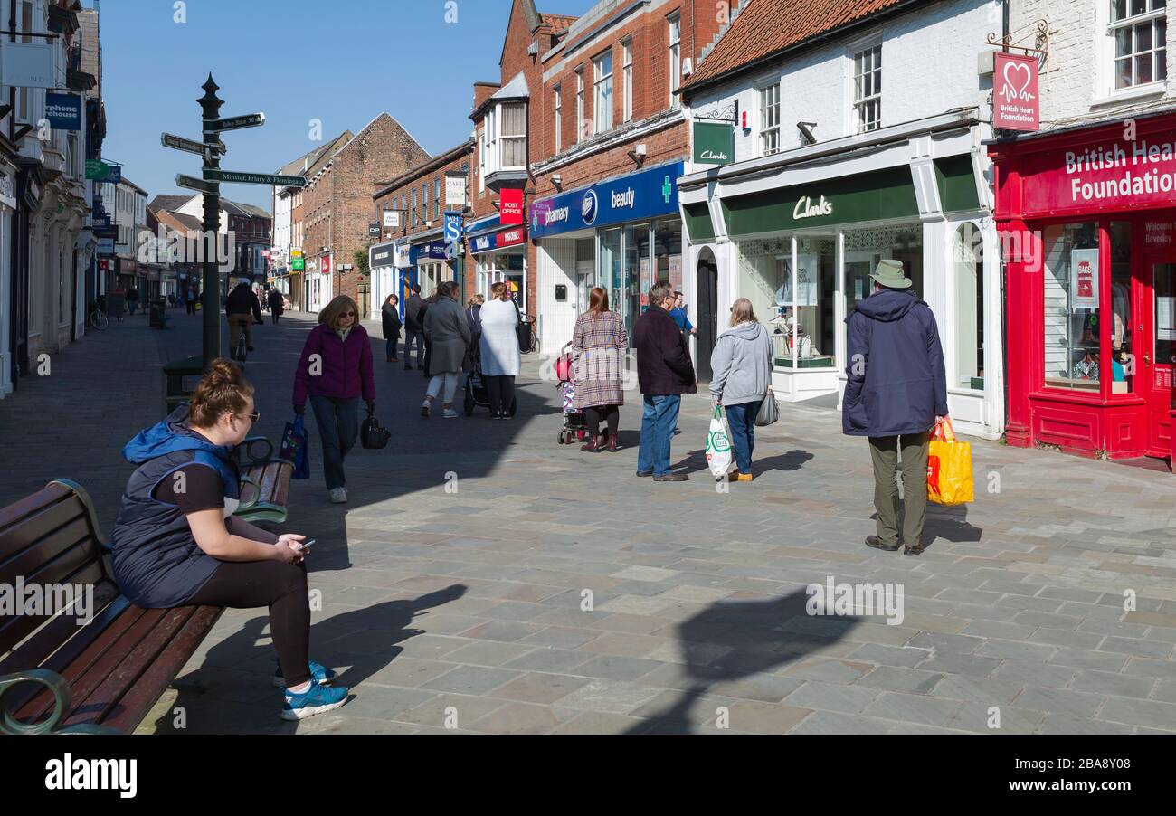 Die Leute stehen nach der Schließung der meisten Geschäfte während des Corona-Virus-Ausbruchs in Beverley, Yorkshire, Großbritannien, in der Warteschlange, um in den Apotheke einzusteigen. Stockfoto