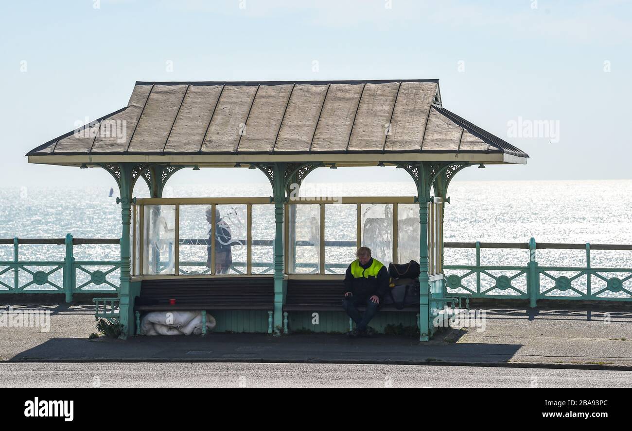 Brighton UK 26. März 2020 - EIN obdachloser Mann sitzt in einem Brighton Seafront Shelter am Tag drei der Regierungen Sperrbeschränkungen während der Coronavirus COVID-19-Pandemie-Krise. Kredit: Simon Dack / Alamy Live News Stockfoto