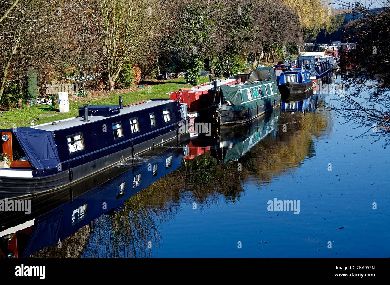 Kanalboot mit Spiegelung im Wasser, Grand Union Kanal in Northolt, London, England Stockfoto