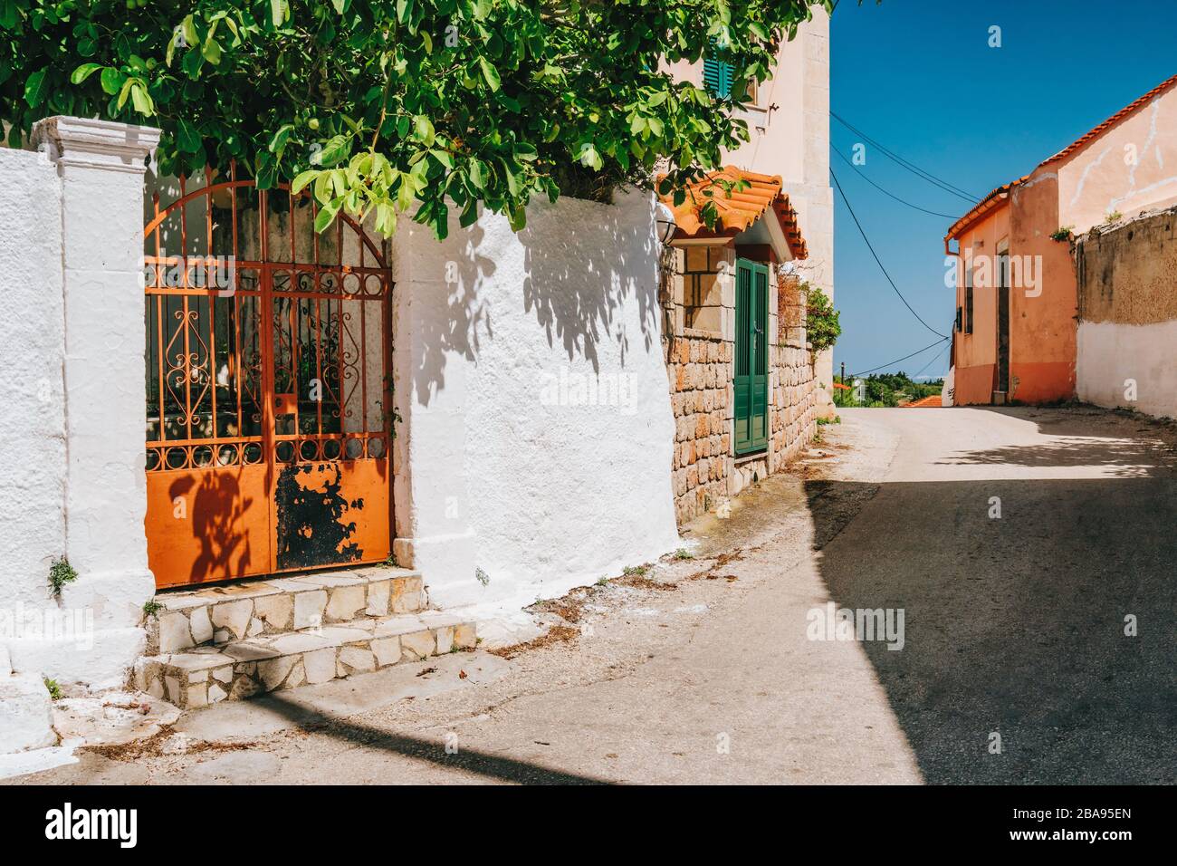 Enge Straße mit weiß getüngten Häusern auf der Insel Kefalonia, Griechenland. Stockfoto