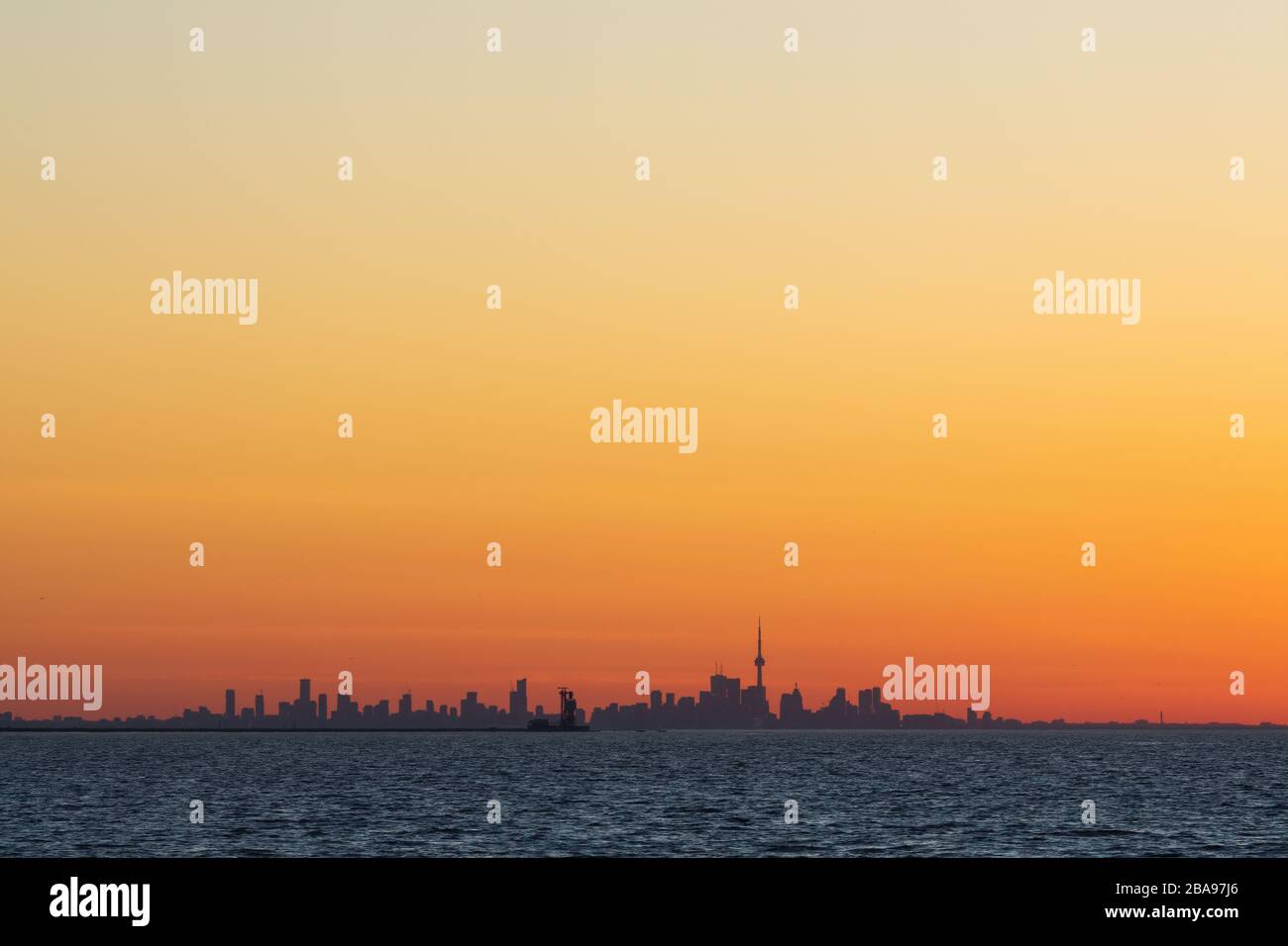 Sonnenaufgang am Ufer des Lake Ontario mit Skyline von Toronto in der Ferne. Stockfoto