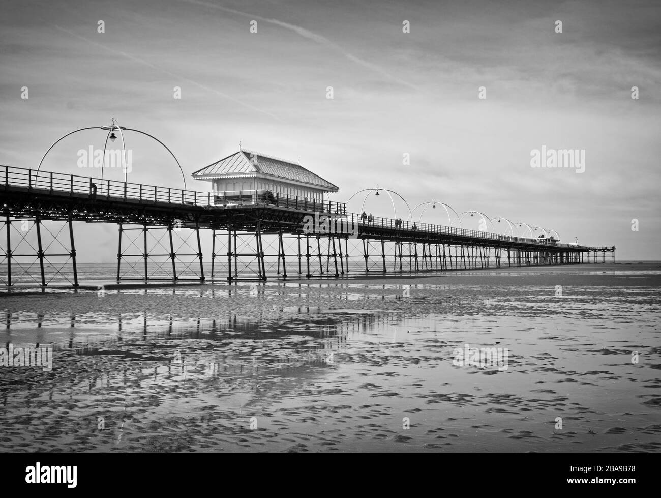 Der historische Pier in Southport, vom Strand aus betrachtet und in traditionellem Schwarzweiß hergestellt Stockfoto