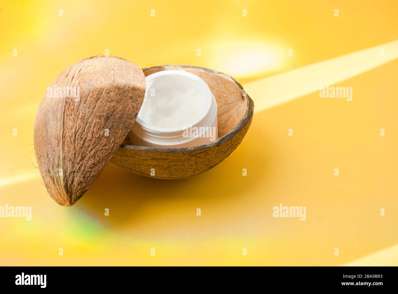 Flasche weißer Kosmetik auf gelbem Hintergrund, harter Schatten. Warten auf Text. Flaches Lay. Stockfoto