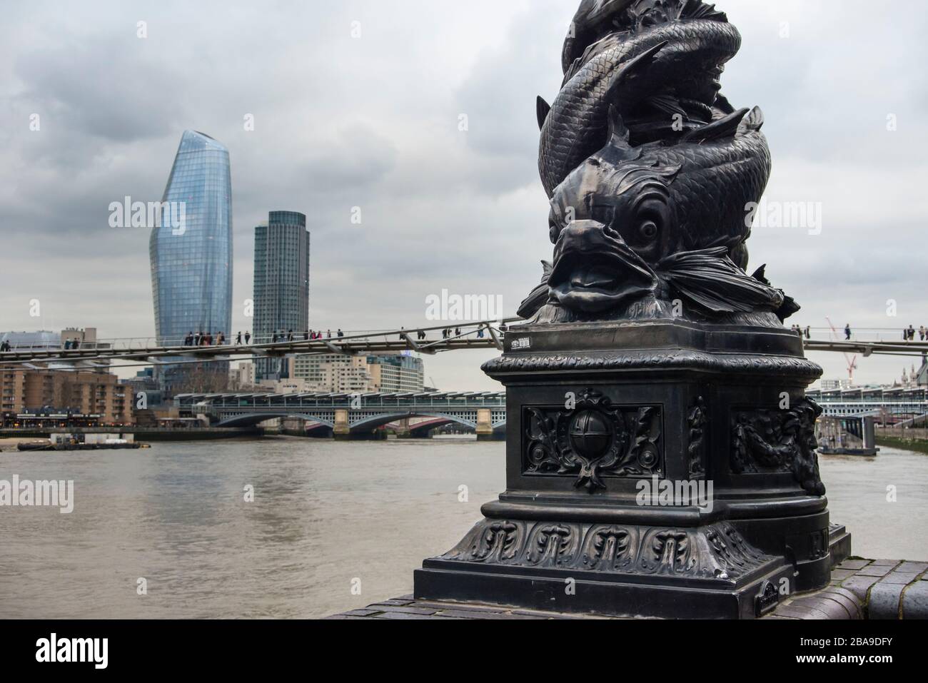 Verzierter Lampenpfosten mit Fischdesign aus Gusseisen und einem Gebäude aus Blackfriars (The Boomerang) und dem Southbank Tower im Hintergrund, London, Großbritannien Stockfoto