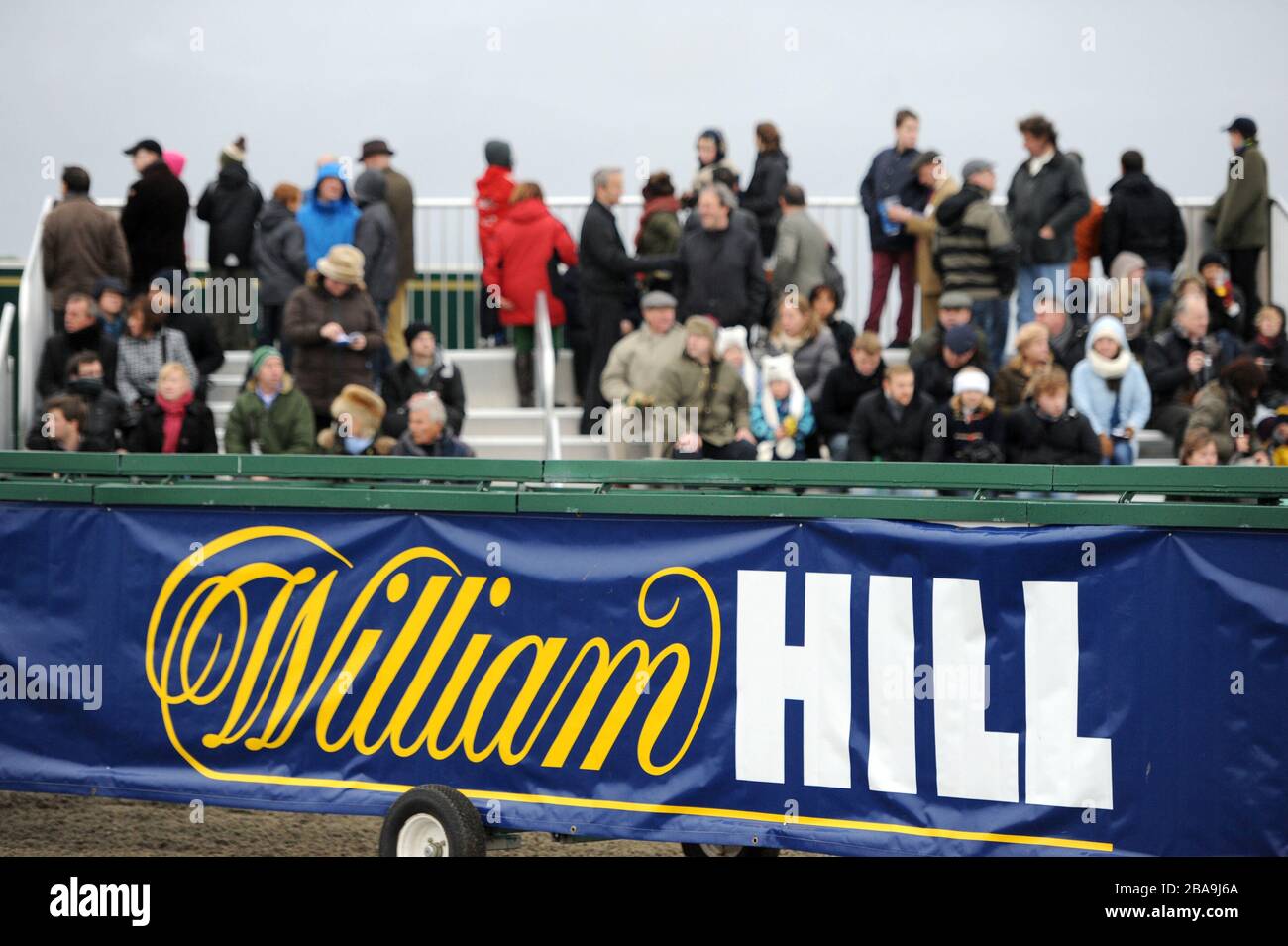 Racegoers sind über die William Hill Beschilderung auf der Kempton Park Racecourse hinaus zu sehen Stockfoto