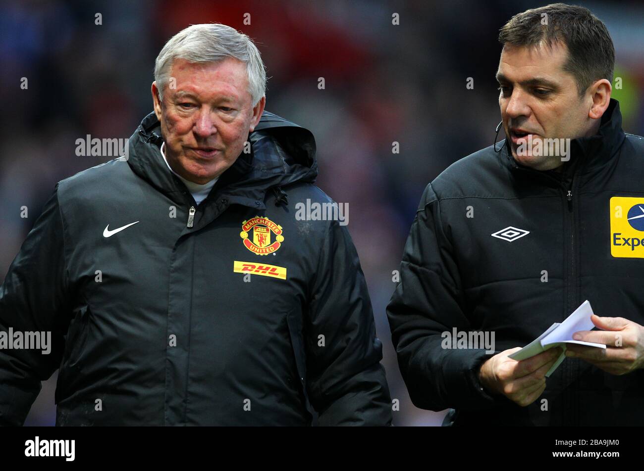 Manchester-United-Manager Sir Alex Ferguson (links) spricht zur Halbzeit mit dem vierten offiziellen Phil Dowd Stockfoto