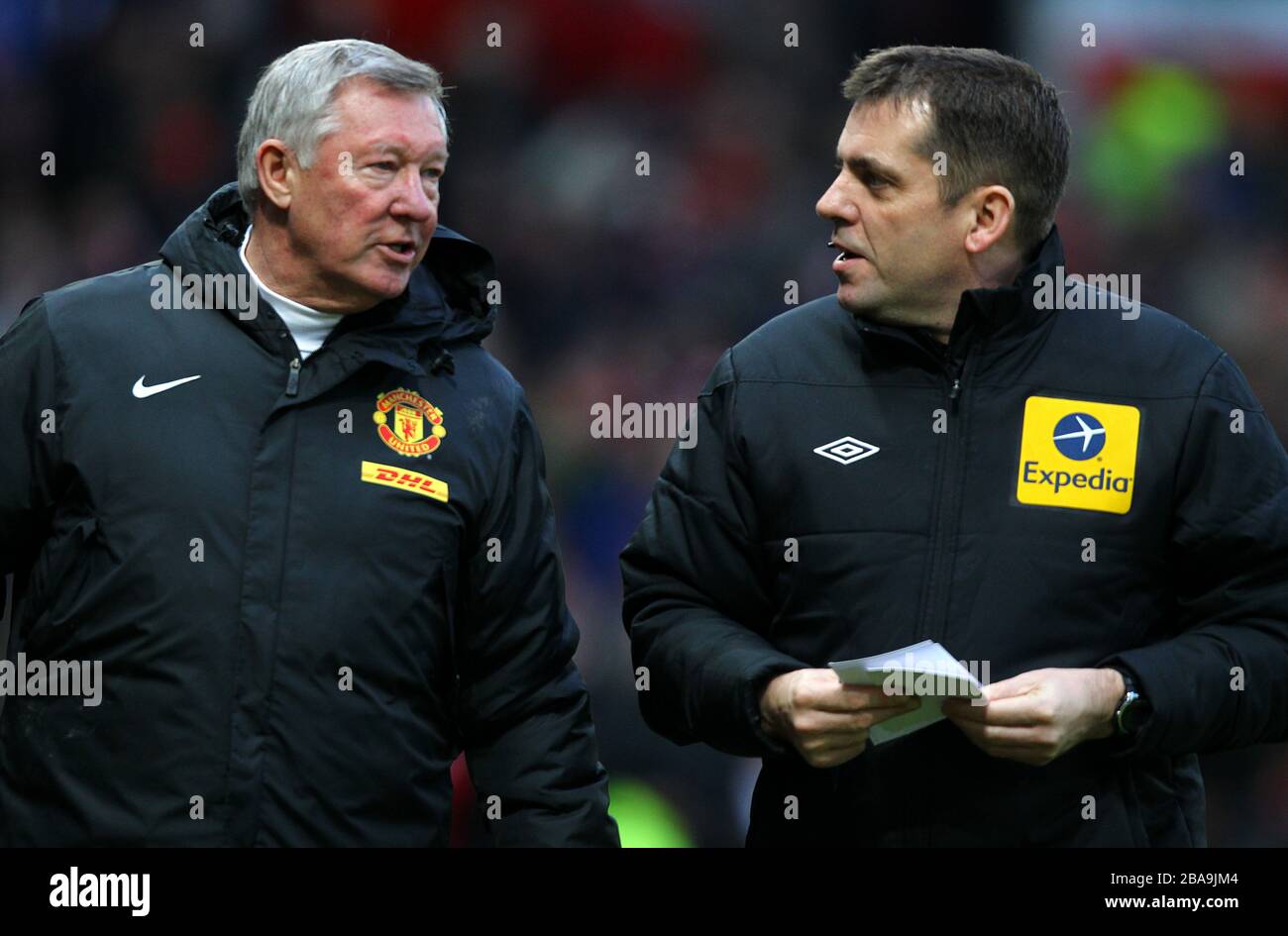 Manchester-United-Manager Sir Alex Ferguson (links) spricht zur Halbzeit mit dem vierten offiziellen Phil Dowd Stockfoto