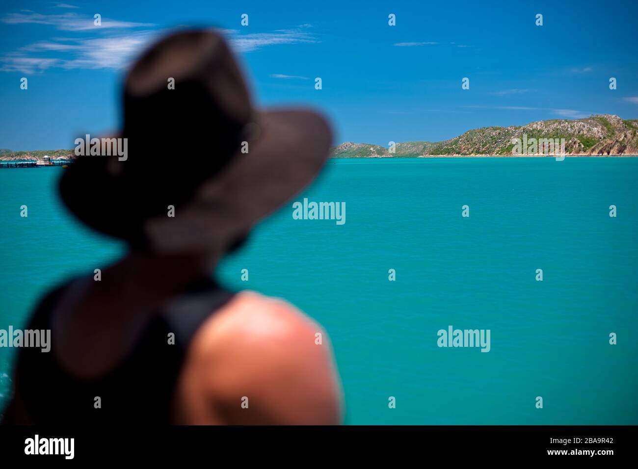 Ein Mann in trägt ein ikonisches Symbol der australischen Kultur, denkt nachdenklich, während er zwischen Inseln in Westaustralien reist. Stockfoto