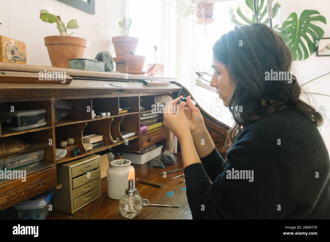 Weiblicher Juwelier mit Schwerpunkt auf die Schaffung von kleinen Stück zu Hause Studio Raum Stockfoto