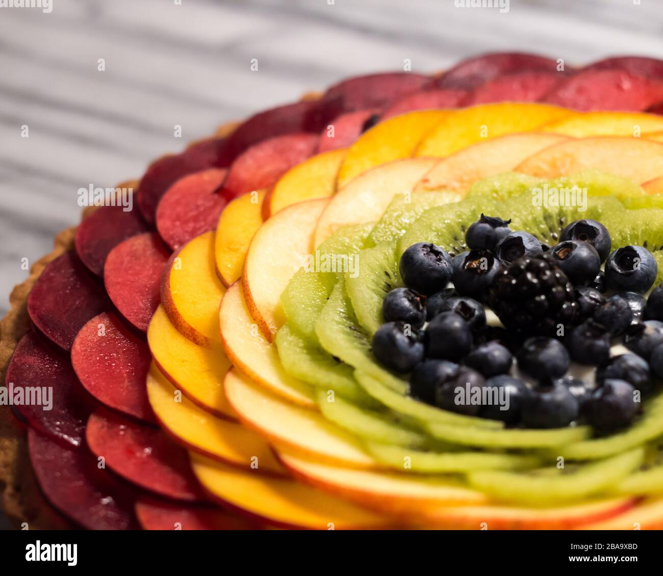 Obsttarte mit Regenbogen auf Marmorpastei Stockfoto