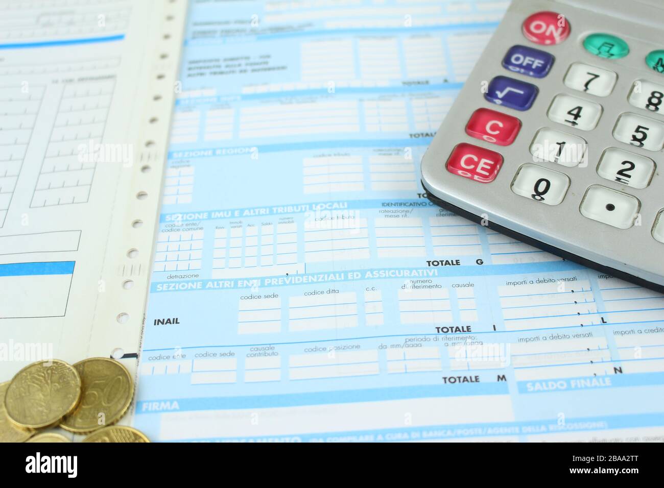 Formular F23/F24 zur Zahlung von Steuern in Italien an die Bank. Details mit Taschenrechner und Euromünzen. Stockfoto