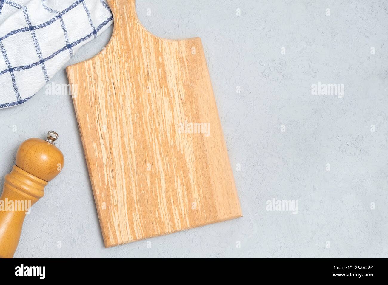 Draufsicht über leere Holzkochplatten und Kochutensilien auf neutralem Betonhintergrund Stockfoto