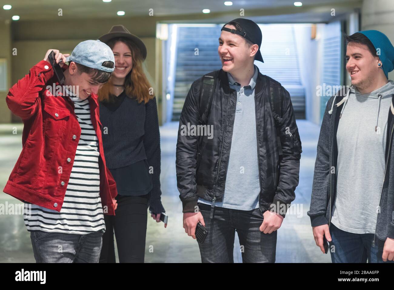 Gruppe junger Freunde, die lachen, Spaß im Saal des U-Bahnhofs zu haben - Stadtfreundschaftskonzept mit tausendjährigen Menschen, die spazieren gehen und Stockfoto
