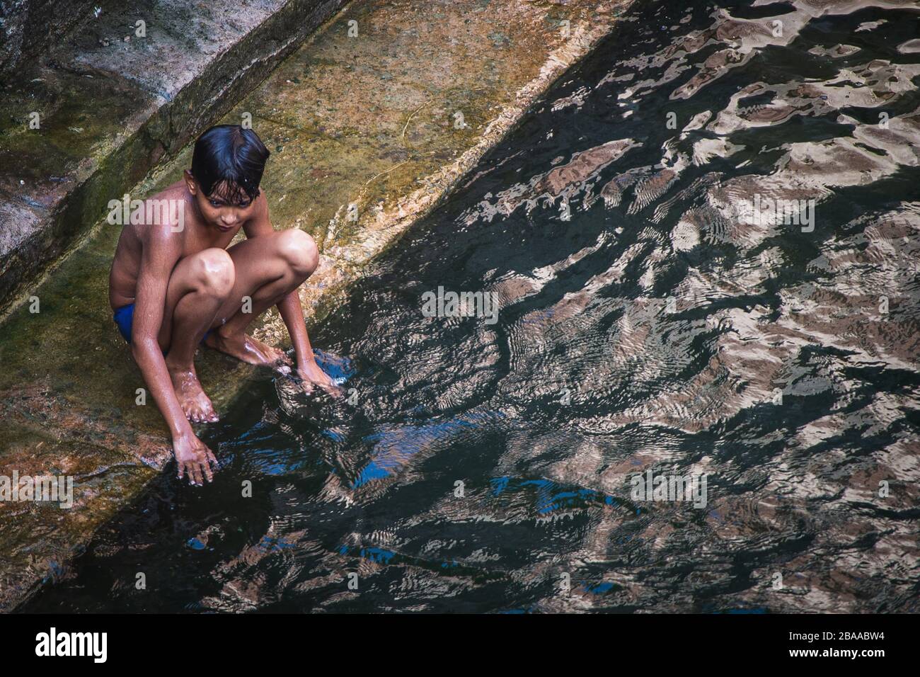 Junge, der in einem Stiefbrunnen in Jodhpur, Rajasthan, Indien spielt Stockfoto