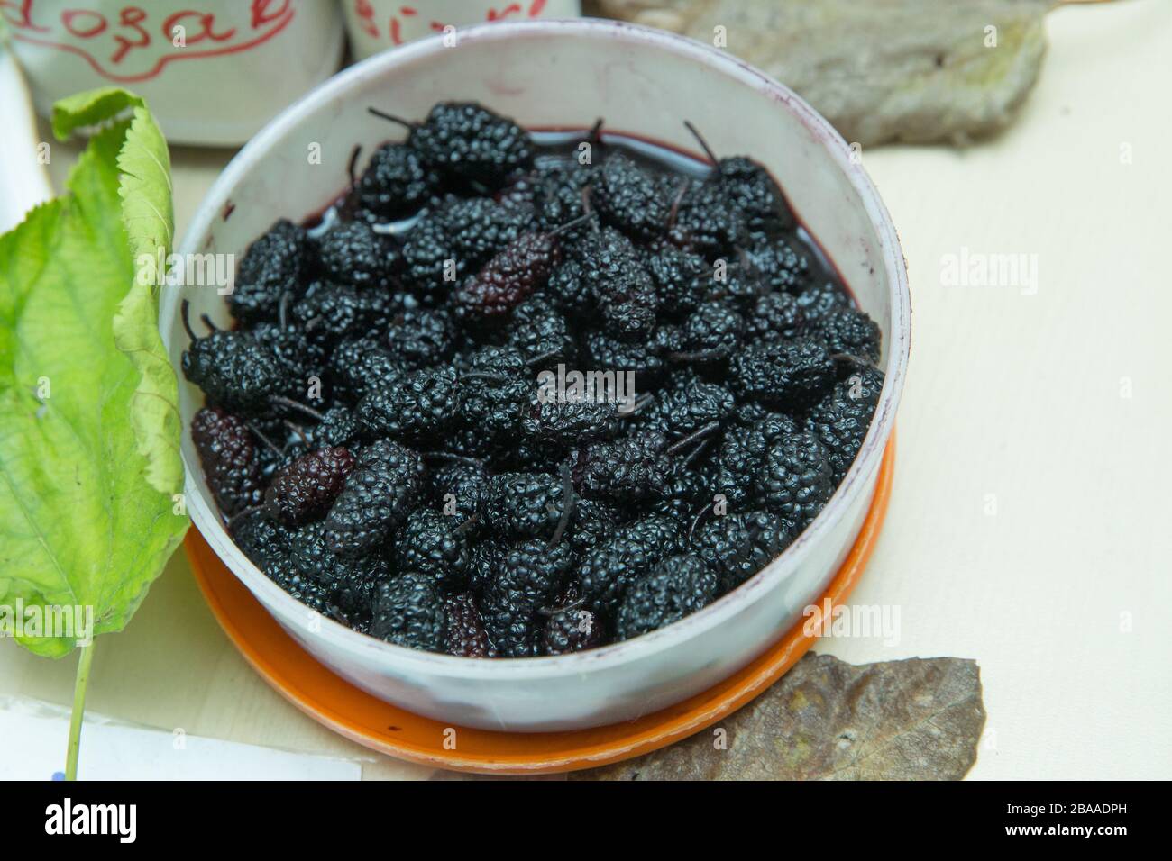 Schwarze Maulbeere in einer Schüssel. Schwarze Beeren auf Weiß