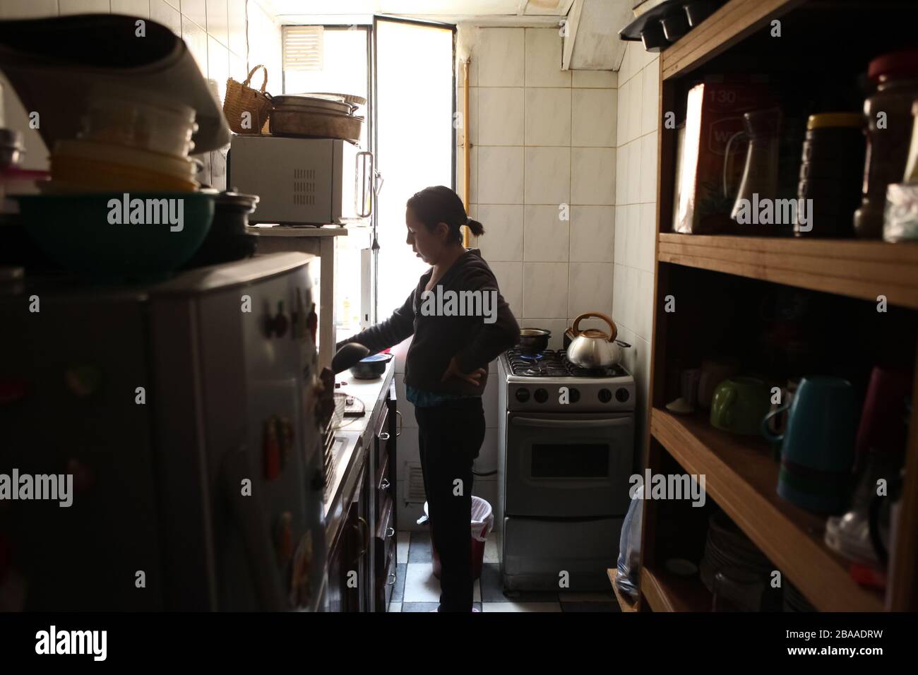 Die bolivianische Frau bereitet ihr Essen für ihre Familie in ihrer Hausküche vor. Credits: Abad Miranda Stockfoto