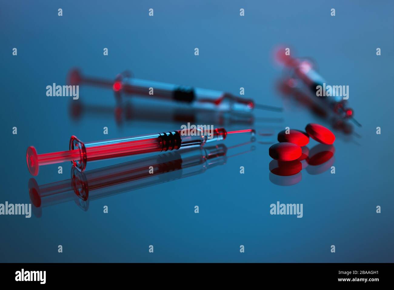 Spritzen, Tabletten, Desinfektionsmittel und Virenschutzmaske auf dunklem Hintergrund, Impfstoff gegen den Covid-19-Corona-Virus und Medikamente Stockfoto