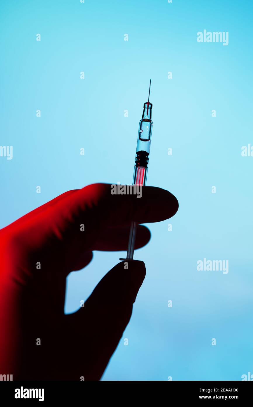 Spritzen, Tabletten, Desinfektionsmittel und Virenschutzmaske auf dunklem Hintergrund, Impfstoff gegen den Covid-19-Corona-Virus und Medikamente Stockfoto