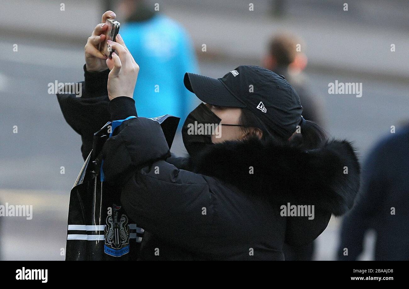 Ein Fan von Newcastle United in einer Gesichtsmaske nimmt ein Foto auf Stockfoto