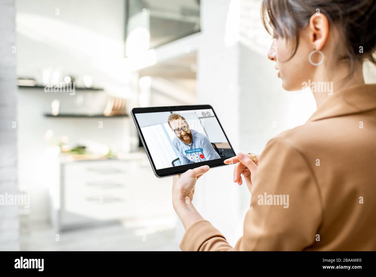 Geschäftsfrau, die mit einem digitalen Tablet einen Videoanruf mit Kollegen führt, während sie von zu Hause aus arbeitet Stockfoto