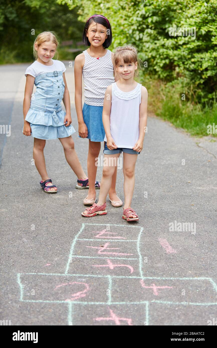 Drei Kinder spielen im Kindergarten ein Hopping-Spiel zusammen Stockfoto