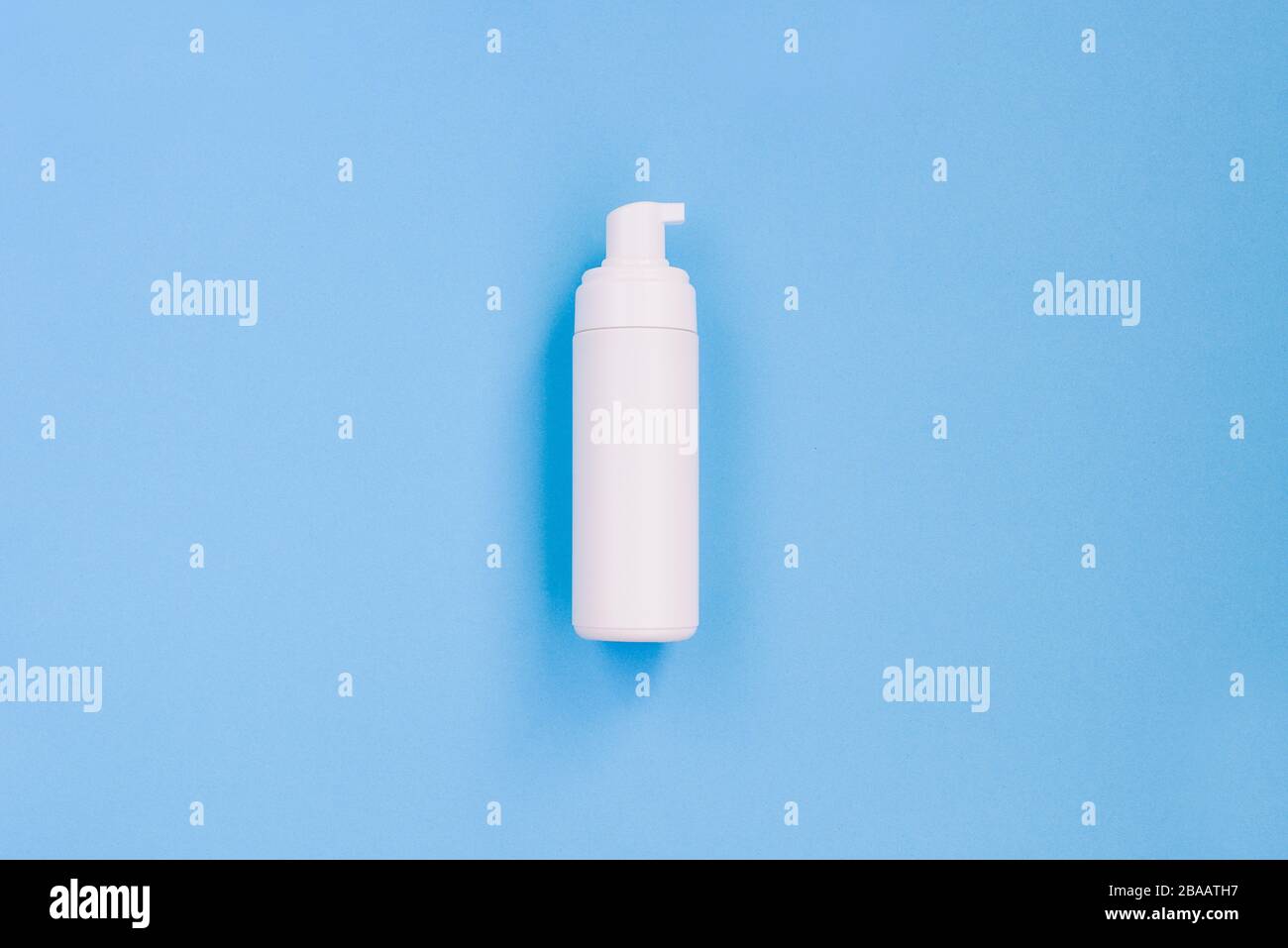 Weiße Flasche mit Spender auf blauem Hintergrund. Mittel gegen Viren und Bakterien. Hygiene und Gesundheitsschutz Stockfoto