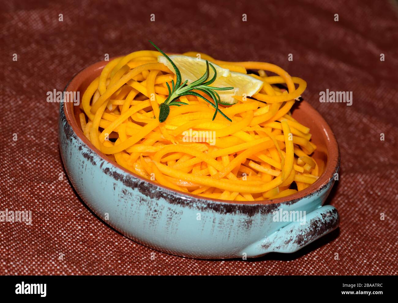 Organische Butternussnudeln in einer Schüssel mit einer Zitronenscheibe und Rosmarinenkraut Stockfoto