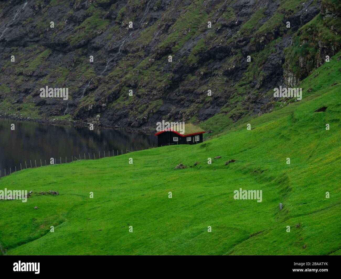 Färöer. Grüne Rasenfelder und traditionelles, mit Gras bedachtes Haus. Saksun Dorf. Stockfoto