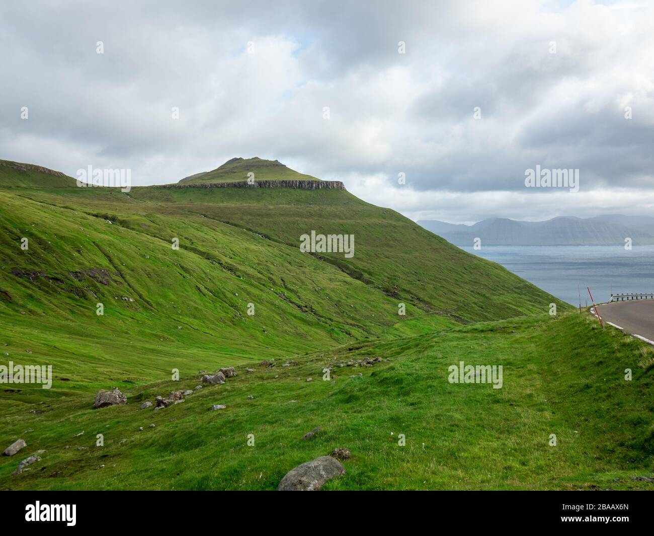Die Färöer, die grünen Felder der Berge. Bewölkter Himmel. Stockfoto