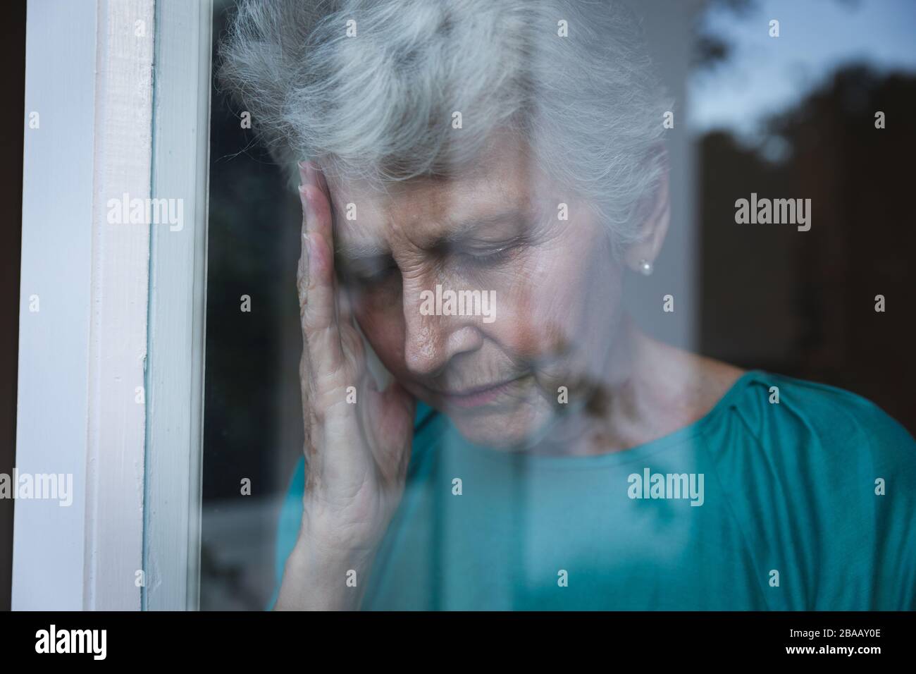 Kaukasische Seniorin zu Hause im Fenster Stockfoto