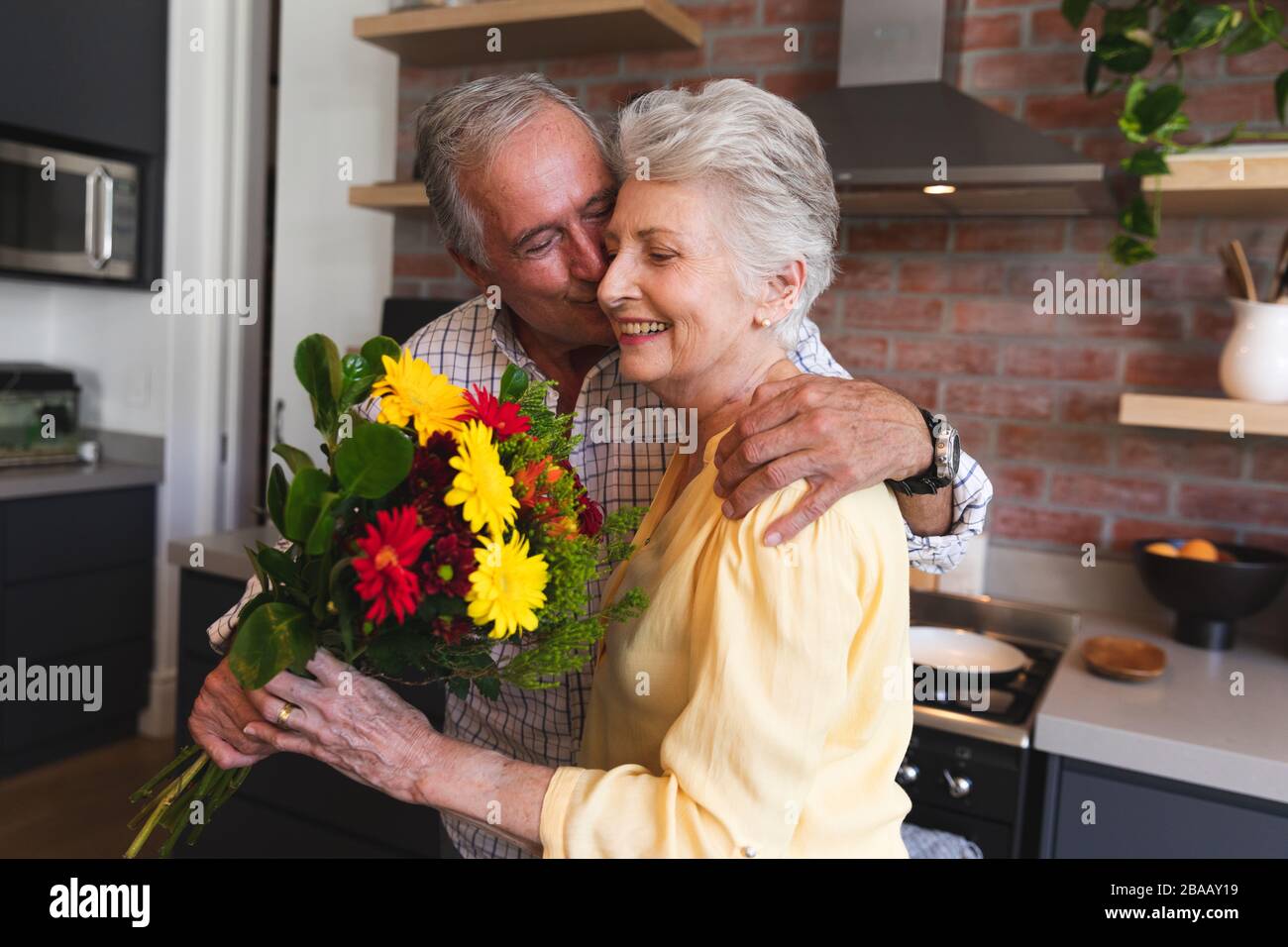 Kaukasischer Senior, der seiner Frau Blumen anbietet Stockfoto