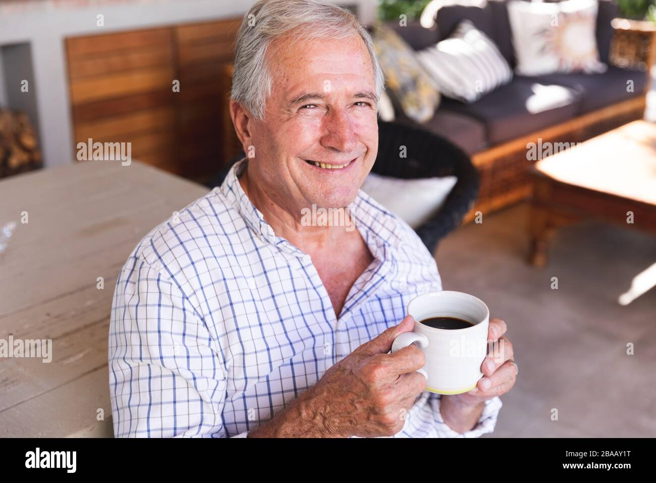 Kaukasischer Senior trinkt zu Hause Kaffee Stockfoto