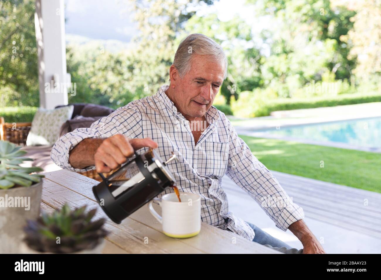 Kaukasischer Senior trinkt zu Hause Kaffee Stockfoto