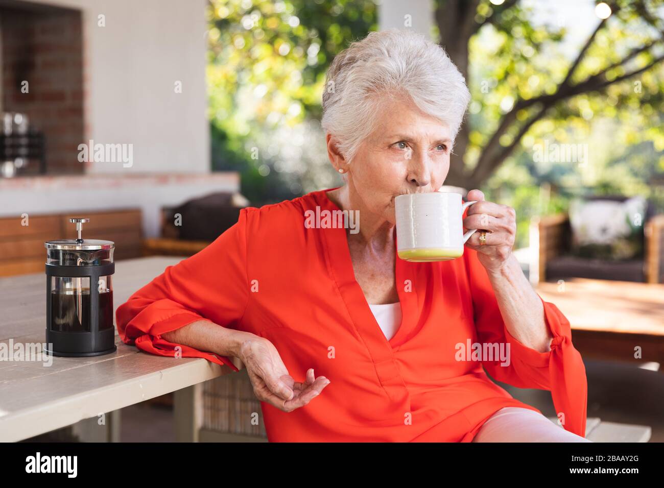 Kaukasische Seniorin trinkt zu Hause Kaffee Stockfoto