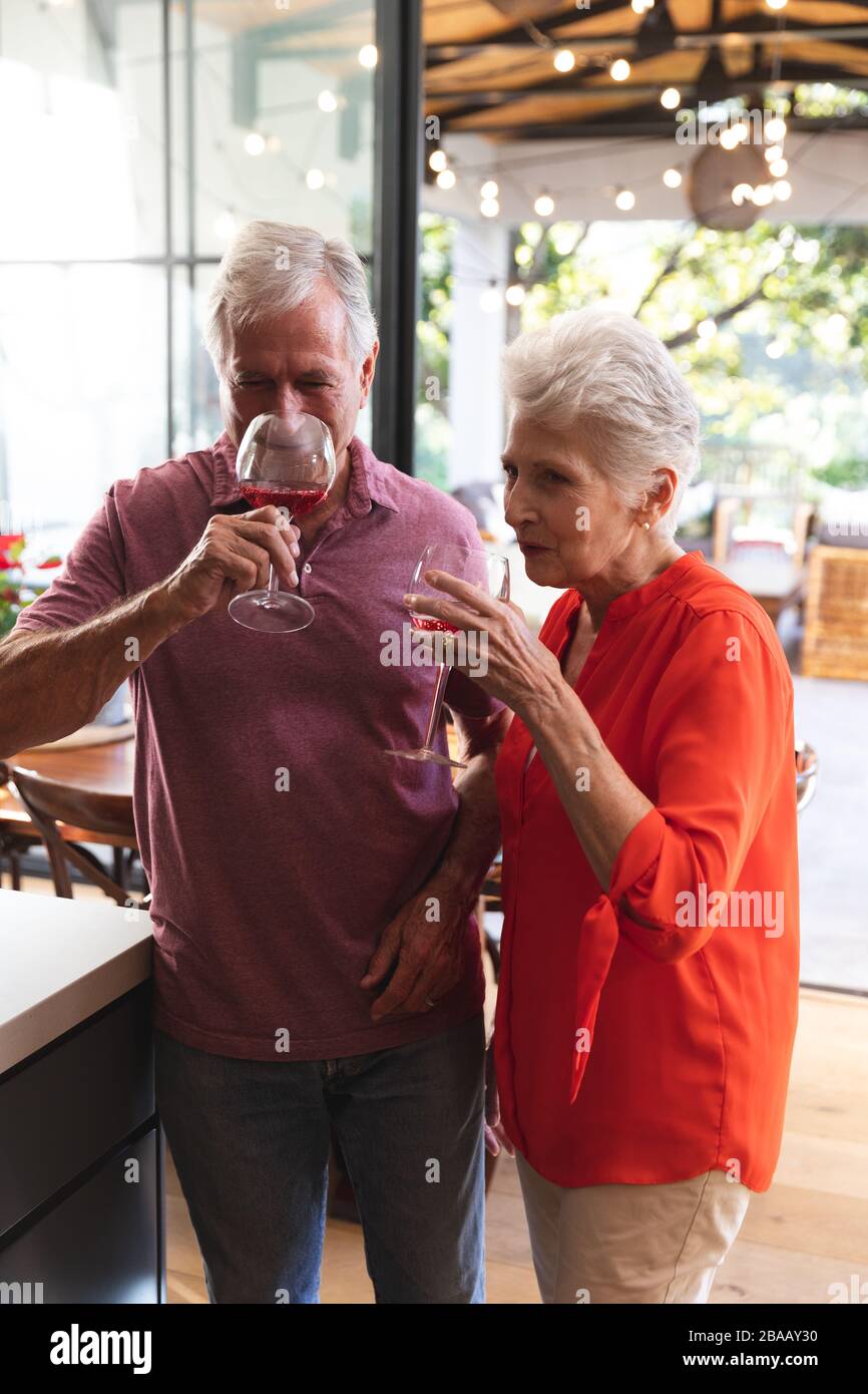 Kaukasisches Senioren-Paar trinkt zu Hause Wein zusammen Stockfoto