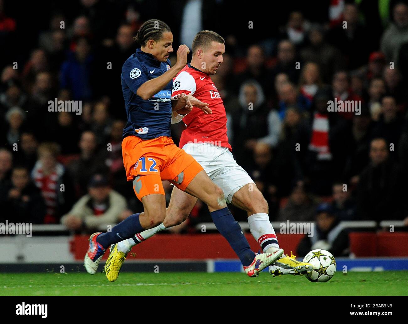 Montpelliers Daniel Congre (links) und Arsenals Lukas Podolski kämpfen um den Ball Stockfoto