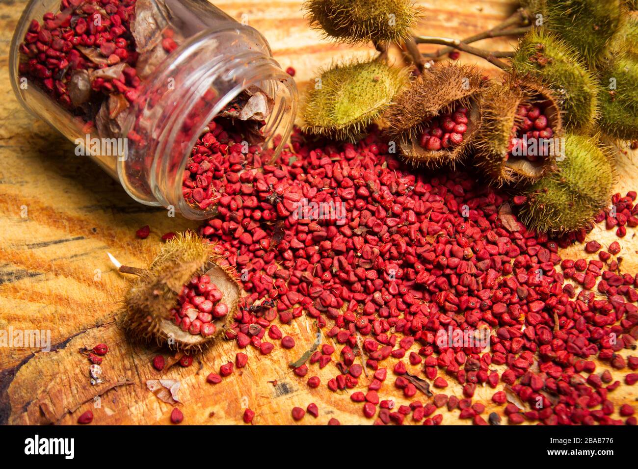 Rote Nannatto-Sämenkonditionierung und Lebensmittelfärbung auf bewaldetem Tisch Stockfoto