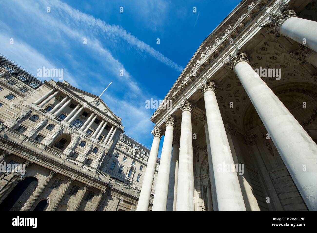 Sonniger Blick auf die Fassade des Gebäudes der Bank of England und der historischen Royal Exchange unter hellblauem Himmel im Finanzzentrum der Stadt London, Großbritannien Stockfoto