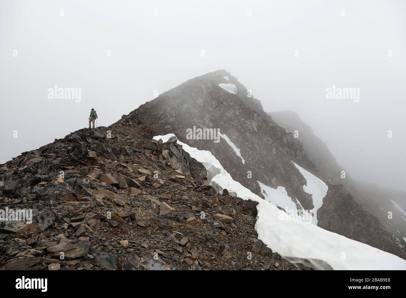 Ein Mann steht in einem Whiteout unterhalb des Gipfels von Cooper Mountain, Kenai-Halbinsel, Alaska. Stockfoto