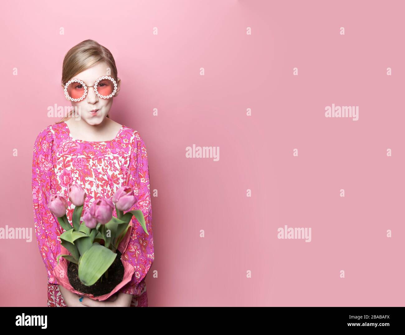 Mod blonde Tween Fair Skin mit rosa Tulpen, rosa Kleid, rosa Hintergrund Stockfoto Mod blonde Tween Fair Skin mit rosa Tulpen, rosa Kleid, rosa Hintergrund Stockfoto