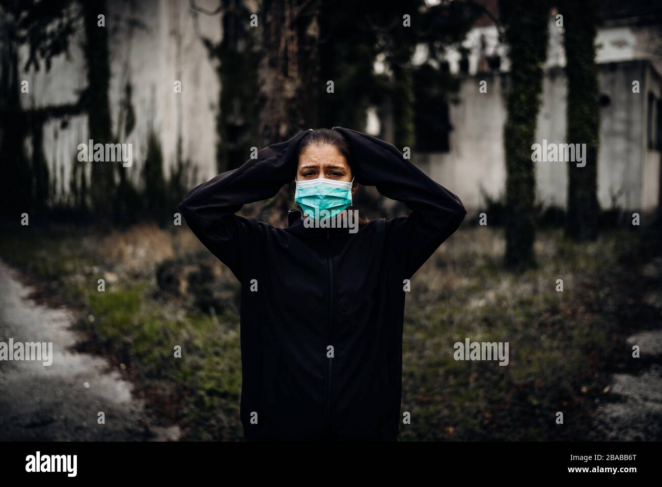 Verwüstete weinende Frau, die eine Schutzmaske trägt.infiziert in Zeiten von Epidemie/Pandemie.Panik und Angst vor Infektionen.Leben in kontaminiertem Gebiet.bemerken Stockfoto